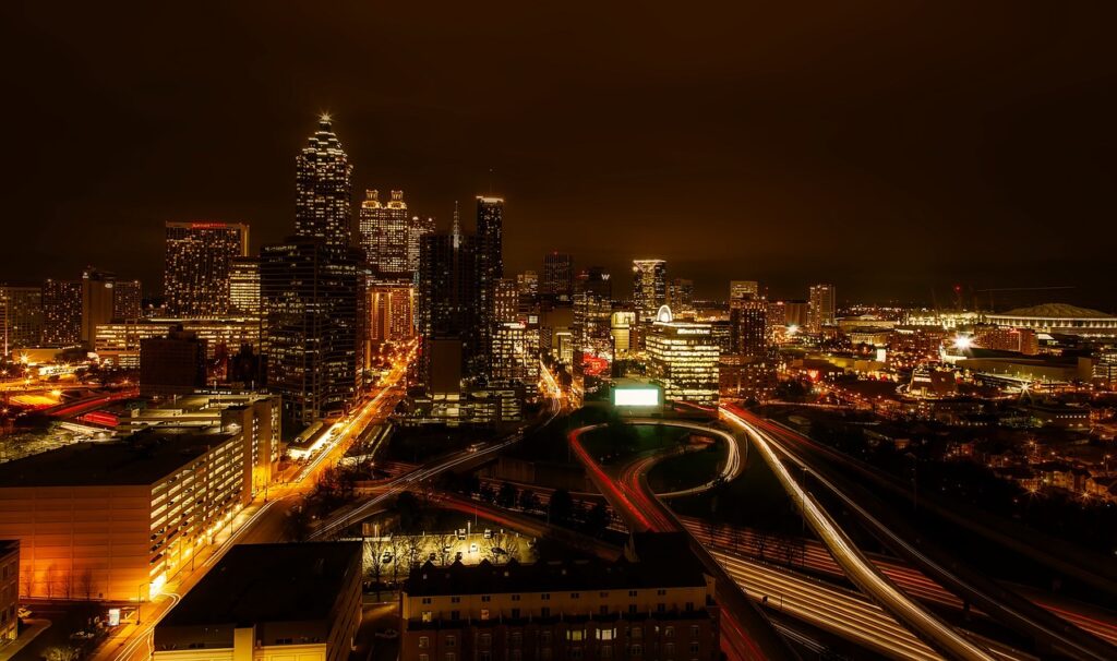 Downtown Atlanta at night, with light trails from traffic on the interstate below the towers
